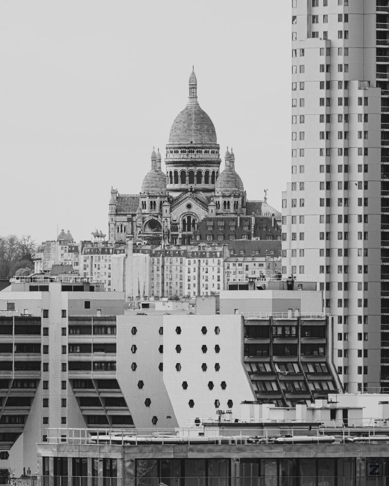 Mont St Michel in the back (in the center of the frame), and tall modern building surrounding it in the "front" 