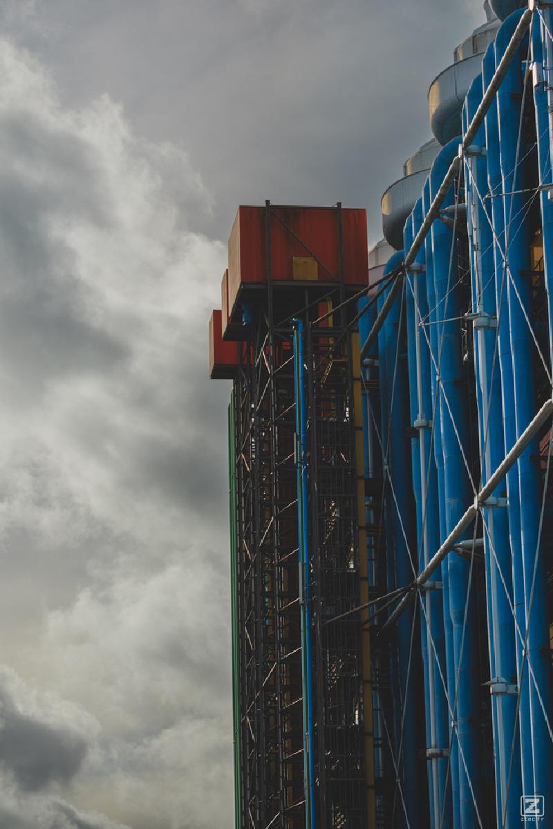 Side of Beaubourg building with two red box on top of industrial building. They look like elevators, but are not.