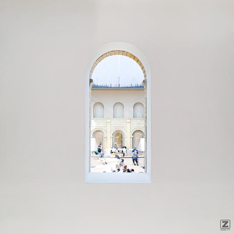 People visible though a hole in a wall in a museum