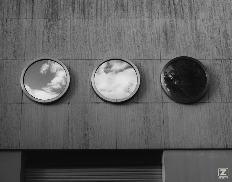 3 round windows on a concrete wall