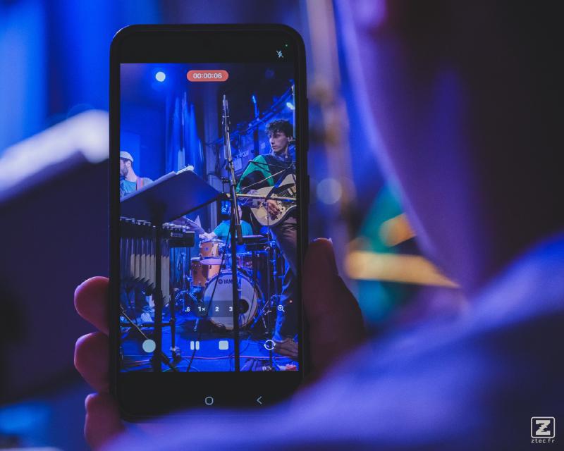 A phone recording the concert. We can see Jean-Loup playing Guitar on the screen