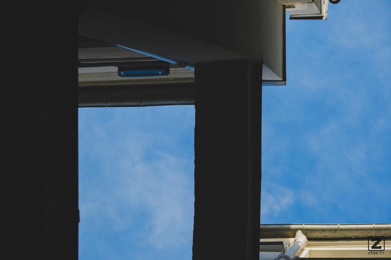 Blue sky with building shapes visible taken from below.