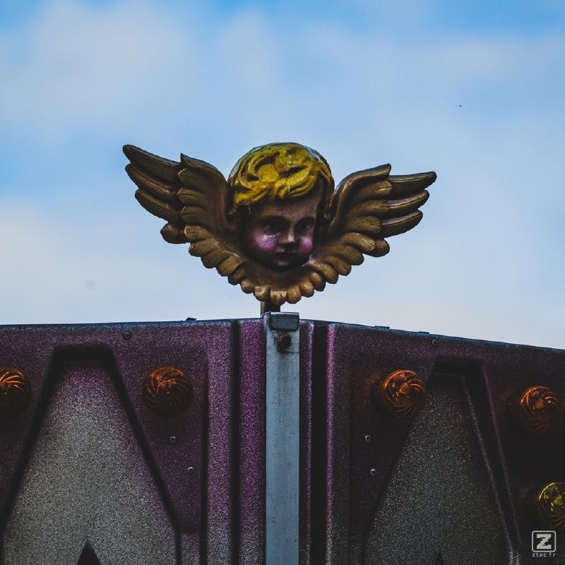 A little ange on top of an attraction ride.