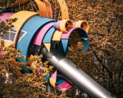 A child playing field structure that look like a colored monster with a metal tube that go out from it's mouth.