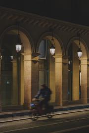 Paris arcades by night with a cyclist passing by