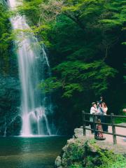 Tourists taking pictures of themselves in front of a beautiful waterfall 