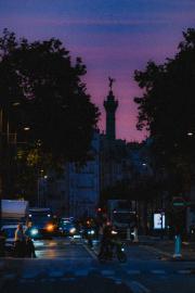 Paris street by early morning, with the Bastille tower piercing building far away