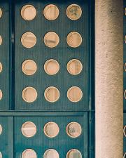 A door with many rounded opening with glass, circled by a golden material.