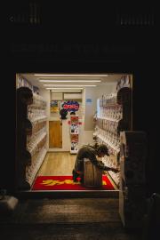 Someone is playing Gashapon in a small shop full of it 