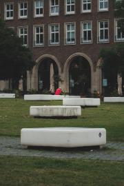 A person in red in the back with white and green foreground in a park.