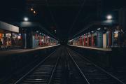 A train station taken from the side, in the middle of the rails
