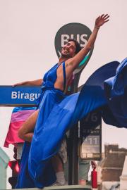 A person on top of a bus stop with a blue dress