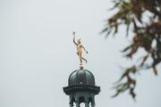 A golden boy statue on top of a monumen