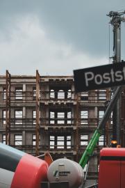 A building under construction with a concrete truck in front
