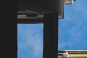Blue sky with building shapes visible taken from below.
