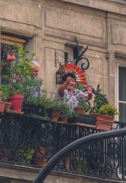 A lady branding a folding fan from here balcony