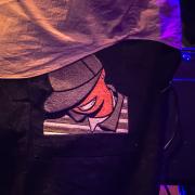 A closeup on the pant's pocket of Theo Croker with a drawing of his double bass friend Eric Wheeler