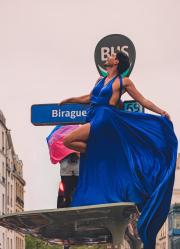 A person on top of a bus stop with a blue dress