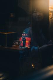 A woman reflection on a window with a Fidel Castro figurine behind