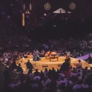 Two sumo at the Paris competition of 2026. They are in the middle of the arena, ready to start the fight.