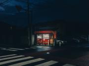 Two Coca Cola dispenser lighted in the middle of the street in the dark