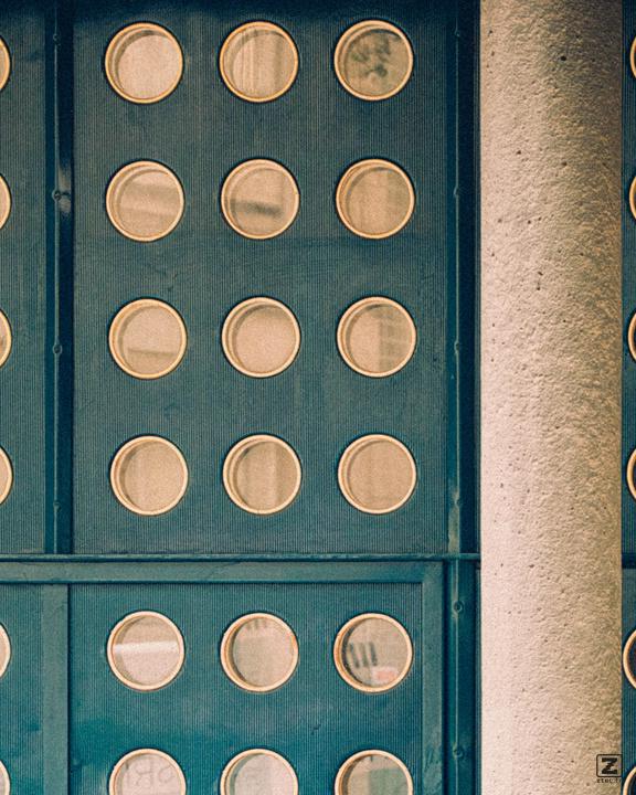 A door with many rounded opening with glass, circled by a golden material.