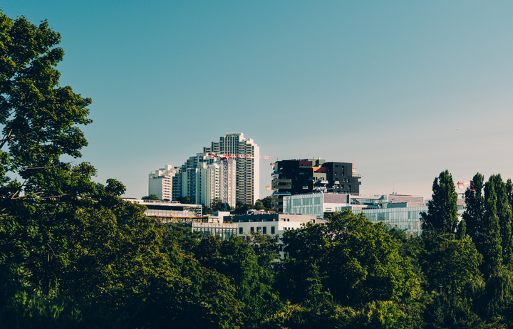 Tall building seen from afar with trees around.