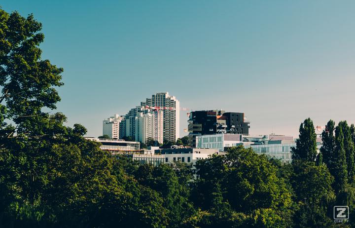 Tall building seen from afar with trees around.