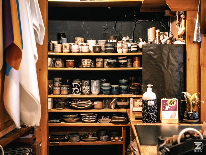 Back-end of a ceramic shop with shelf full of cup and ceramic pot. 
https://www.flickr.com/photos/ztec/53159188912/
