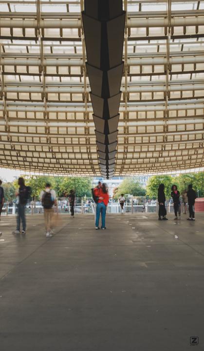 Two persons hugging under the Châtelet canopée. People around them are blurry.