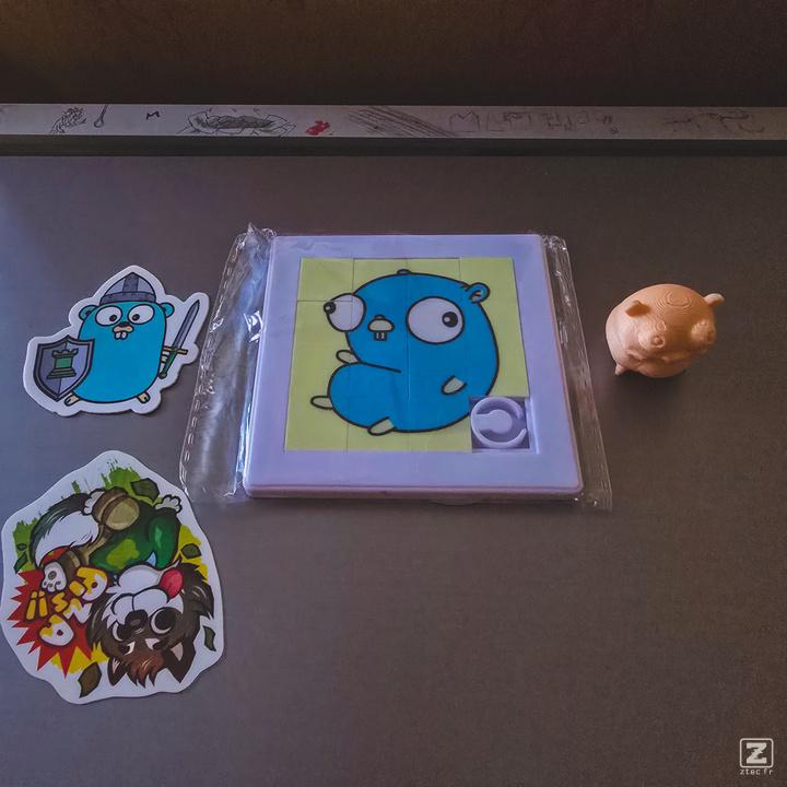 Swag from the Golang room. A sticker, a Puzzle, and a 3d printed figurine. All of a Golang Gopher. 