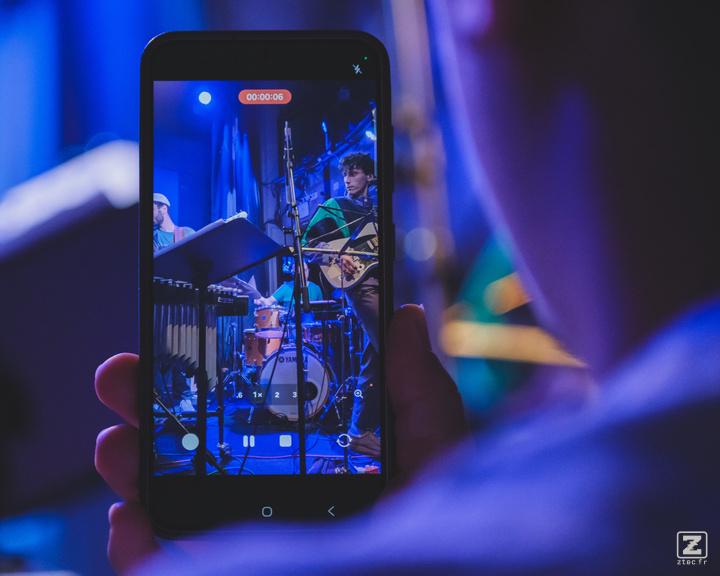 A phone recording the concert. We can see Jean-Loup playing Guitar on the screen