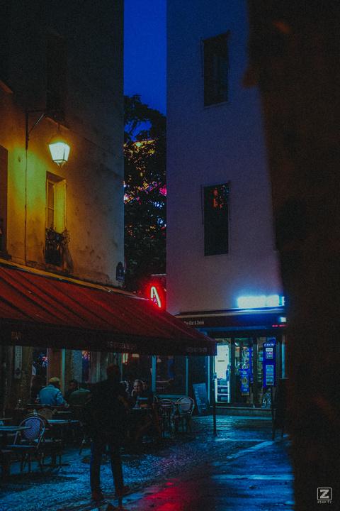 Parisian street with a man walks by a typical bar.
https://www.flickr.com/photos/ztec/53885194516/