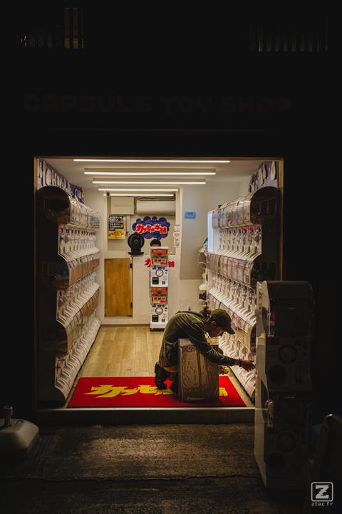 Someone is playing Gashapon in a small shop full of it