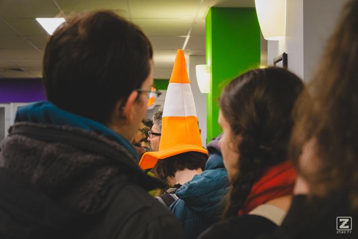 Someone with a VLC cone on their head queuing for coffee.
