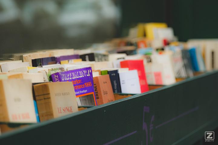 Books aligned in an exterior shelf in front of a bookstore. The focused books is purple with the title "Avortement" talking about abortion.