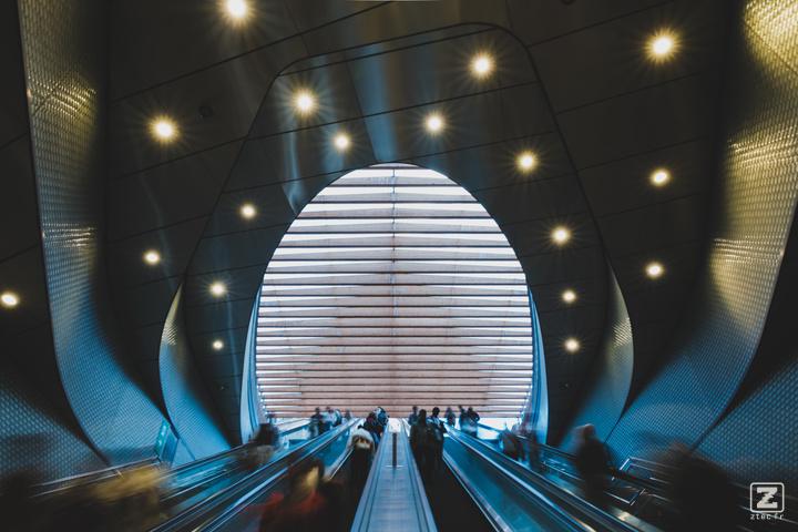 Multiple mechanical stairs going up to an erg shape ceiling 