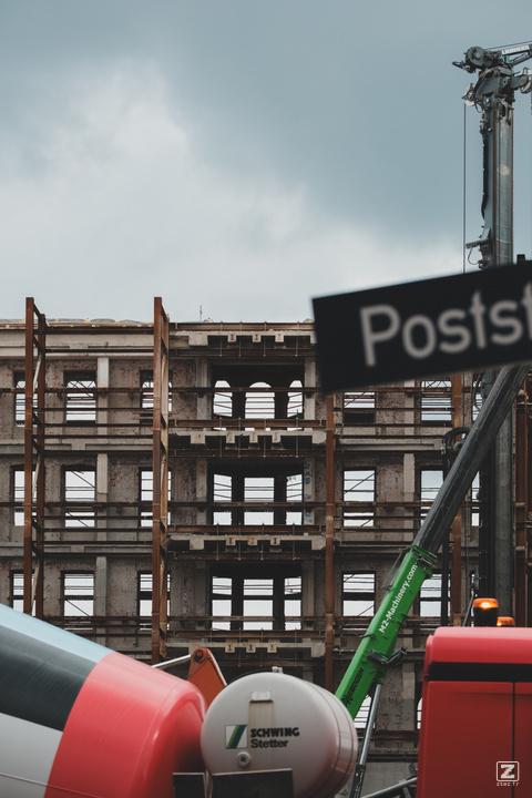 A building under construction with a concrete truck in front