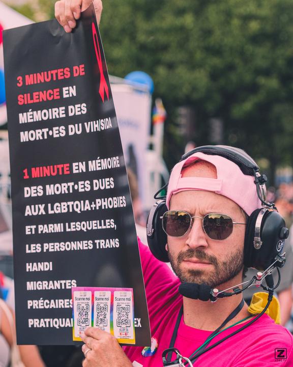 A man with a sign about 3-4 minute of silence for the death of AIDS