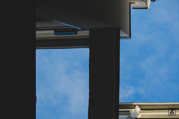 Blue sky with building shapes visible taken from below.