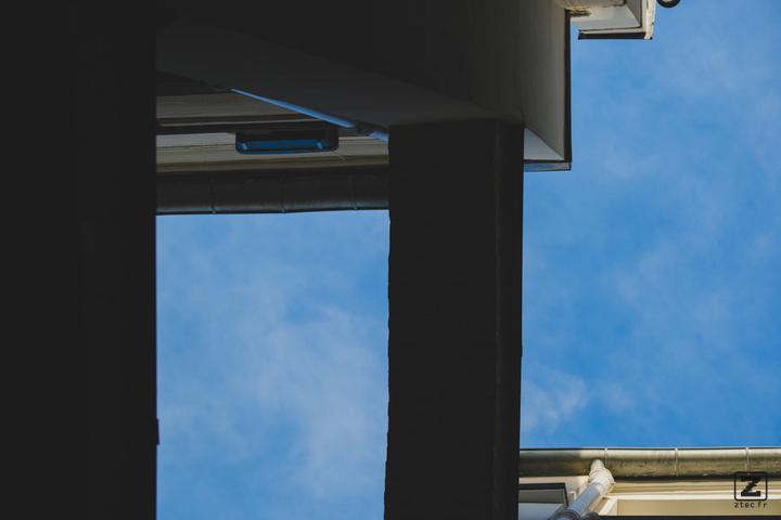 Blue sky with building shapes visible taken from below.
