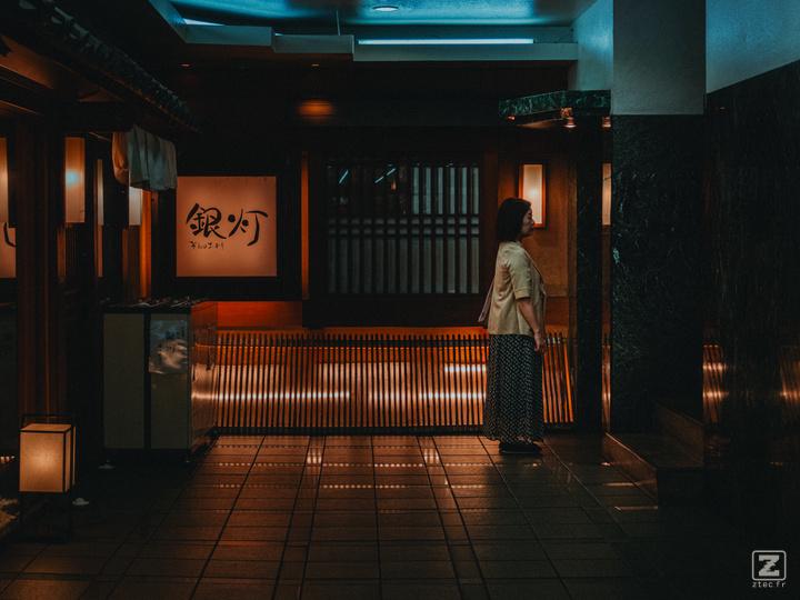 A woman is waiting for the elevator to come in a Street of Sendai