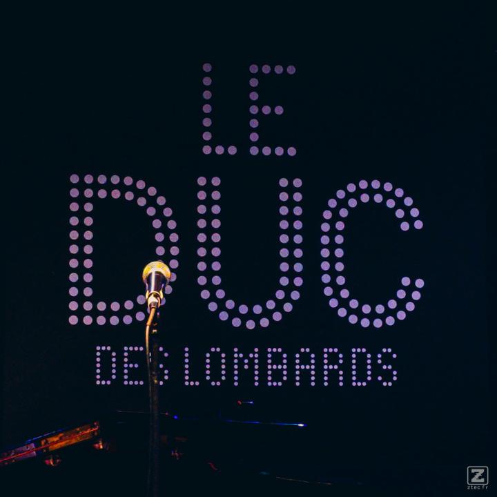 The backdrop of Le DUC des Lombards with a mic in front.