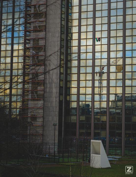A Palestinian flag hanging of a window on a small sky scraper in from of the ULB Brussel.
