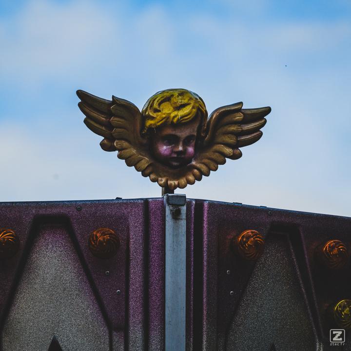 A little ange on top of an attraction ride.
