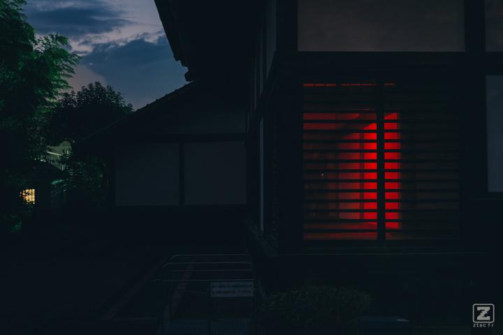 A house taken in the dark. A red glow come from the inside