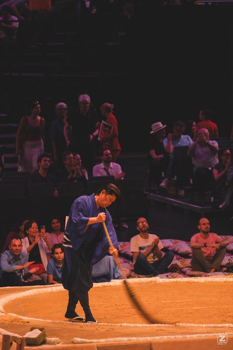Cleaning guy that is browning the sumo arena after a fight