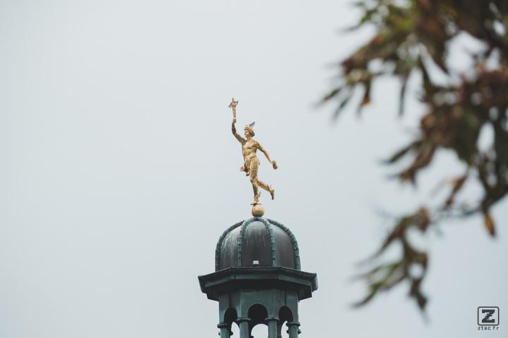 A golden boy statue on top of a monumen
