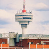 A tv tower sprouting from a red brick building