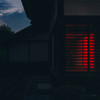 A house taken in the dark. A red glow come from the inside